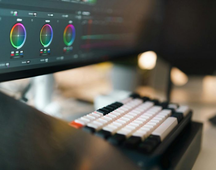 A close-up of a video editing setup featuring a mechanical keyboard and color grading on a monitor.